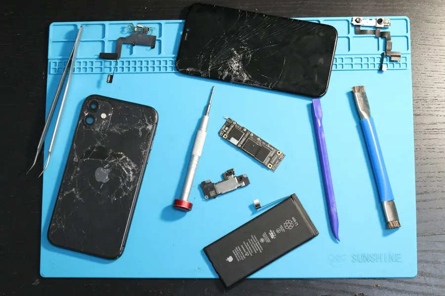 iPhone desmontado com ferramentas de reparo na bancada